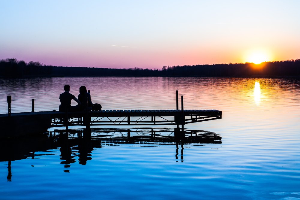 reflection of boat and sunset in water